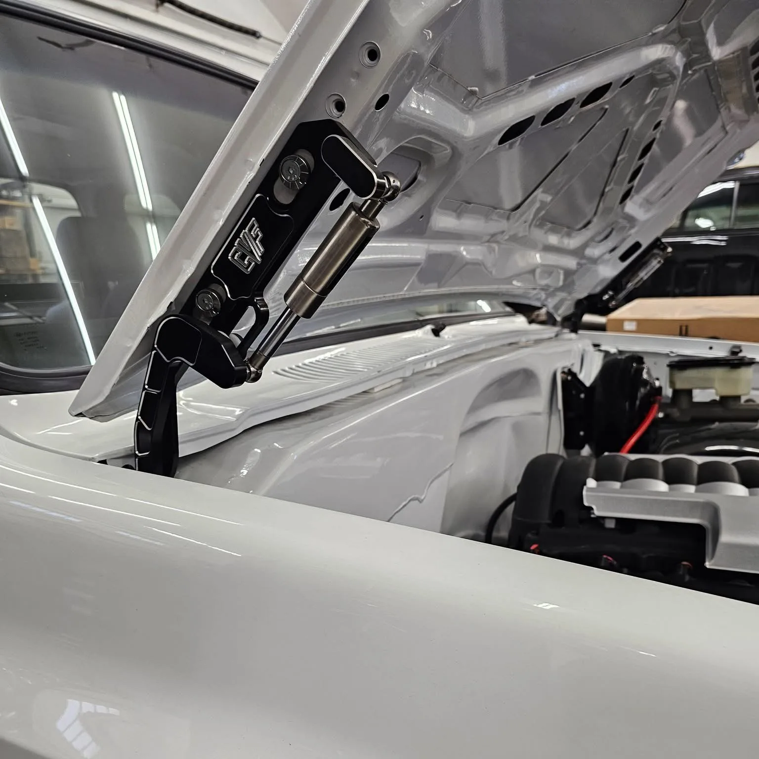 Black billet hood hinges shown installed on an 81-87 Chevy squarebody truck