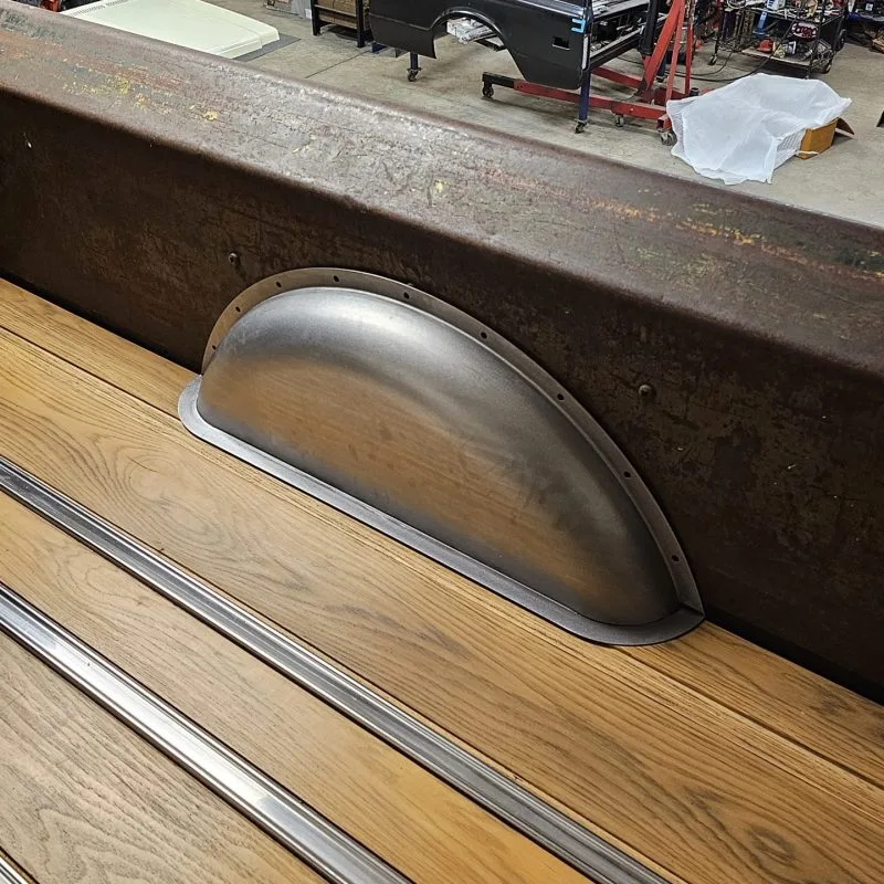 Wheel tubs installed over bed wood in a classic truck bed