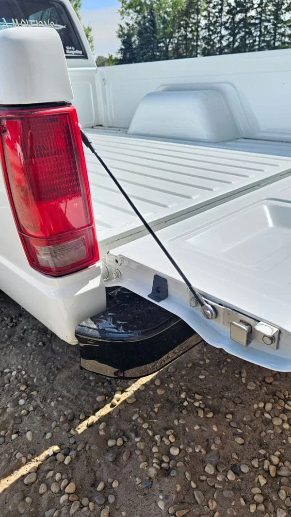Tailgate cable installed on the tailgate of a white Chevy S10 truck