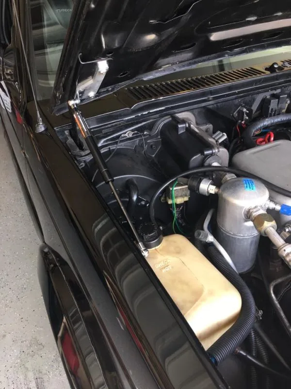 Hood strut kit shown installed on a black 82-93 Chevy S10 truck