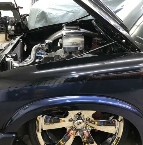 Hood strut kit shown installed on a blue 94-04 Chevy S10 truck