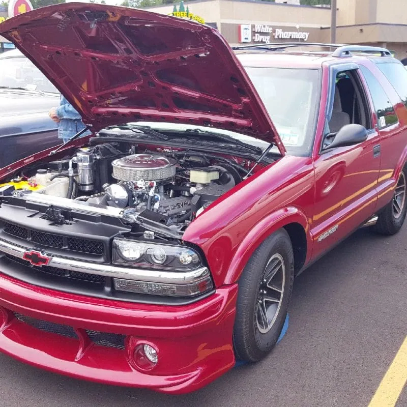 Hood strut kit shown installed on a red 94-04 Chevy Blazer